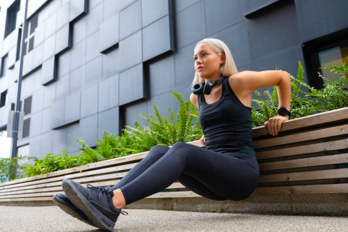 Focused Woman Doing Heavy Triceps Dips Outdoor in the City