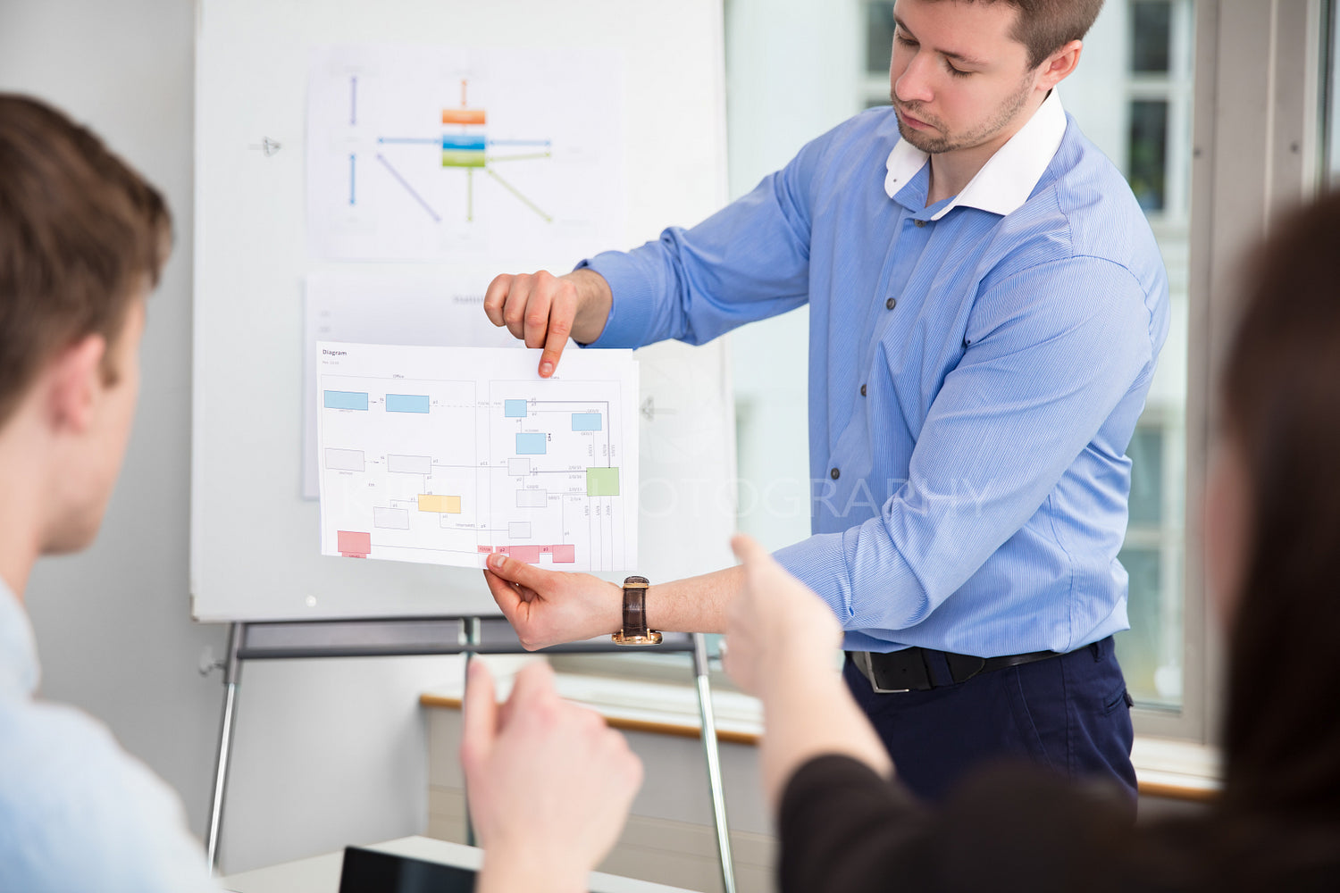 Businessman Showing Chart To Colleagues In Office