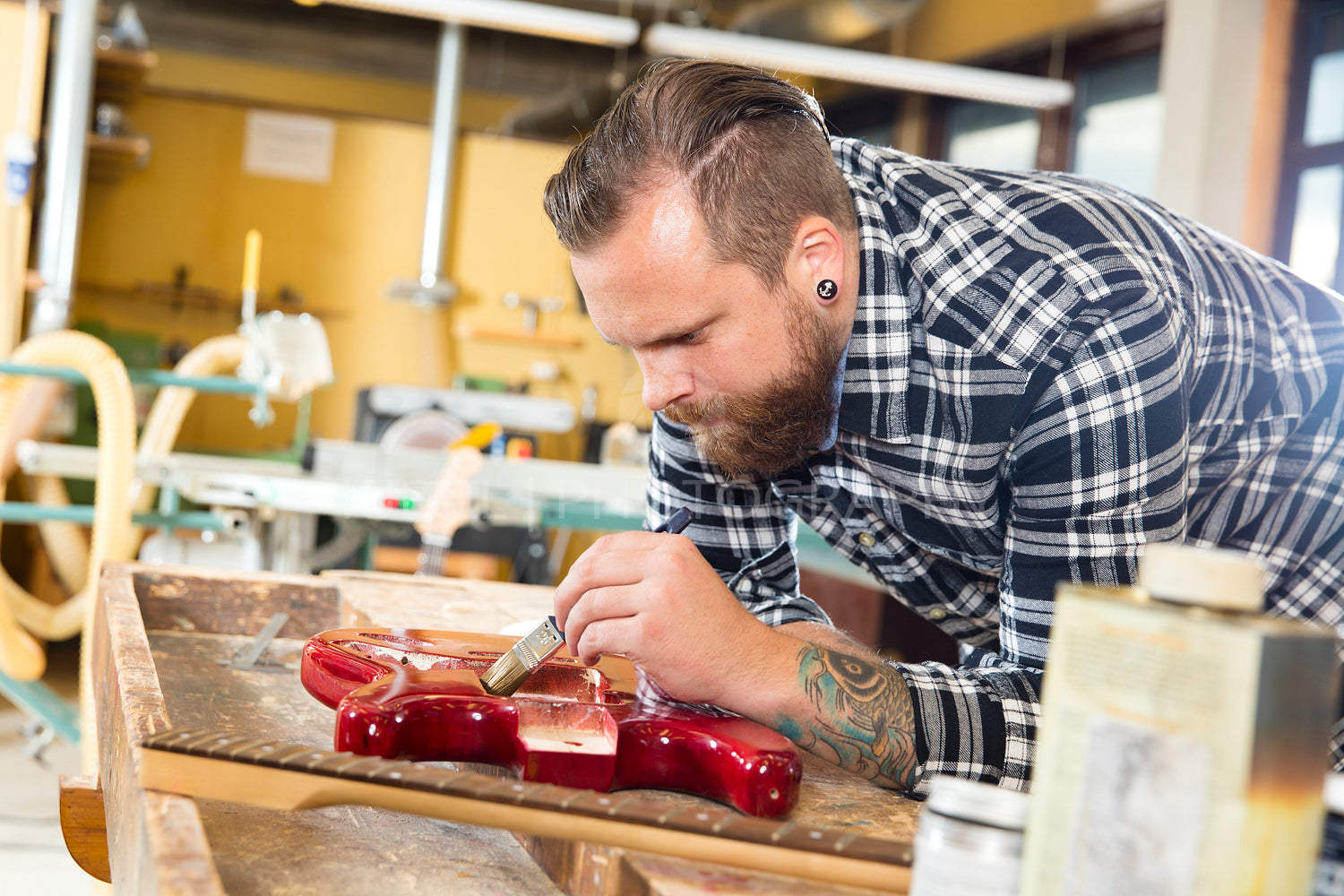 Craftsman working at workshop with a guitar