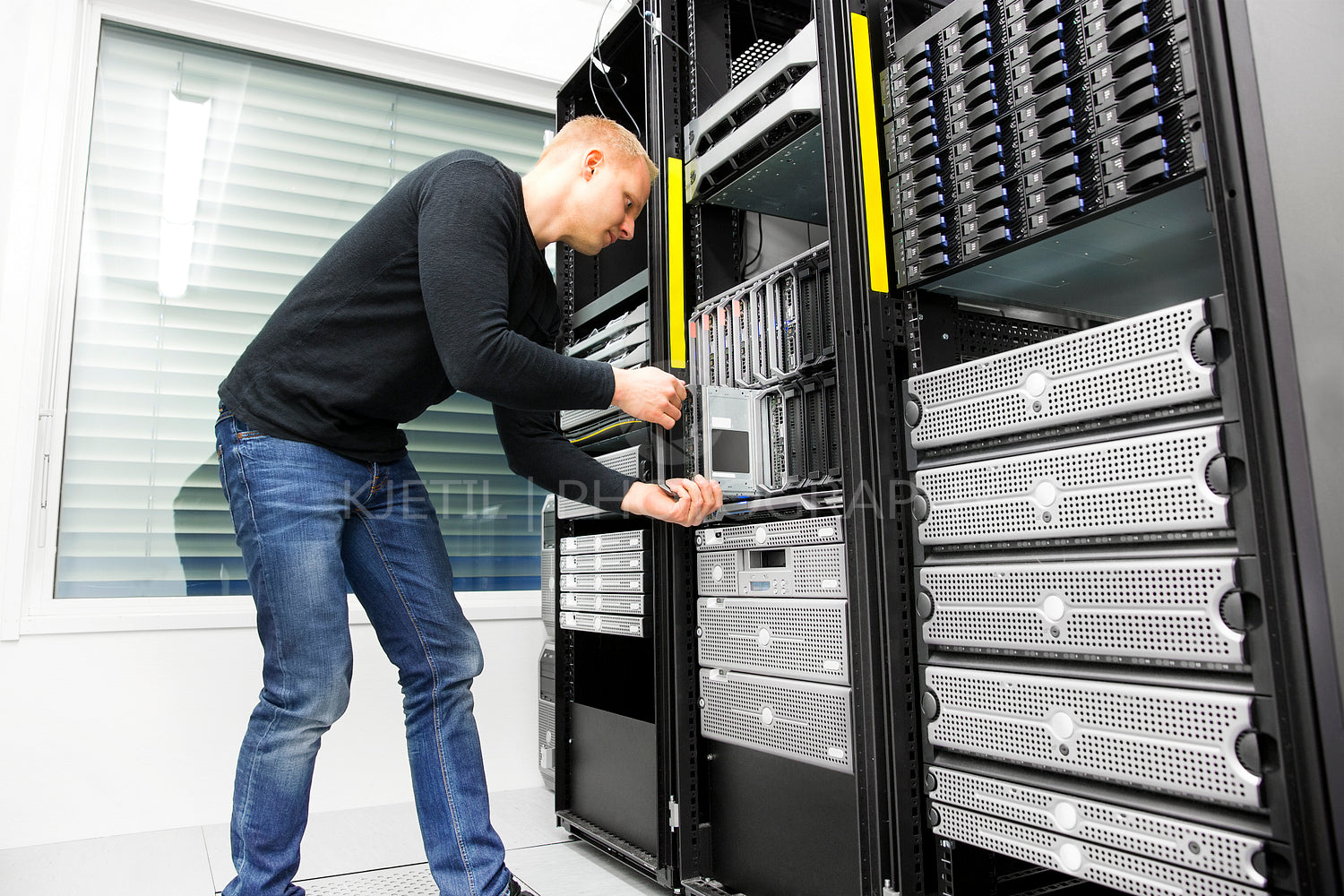 IT engineer installs blade server in datacenter