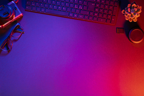 Overhead view of computer keyboard with camera on illuminated table