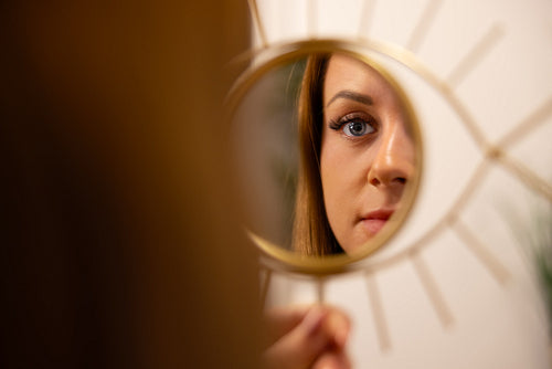 Young Woman Looking At Her Reflection In Beauty Clinic