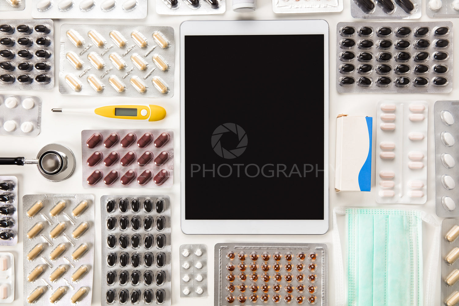 Digital Tablet Surrounded By Colorful Pills On Table