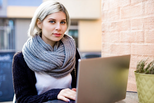 Young Woman Working On Laptop At Outdoor Cafe