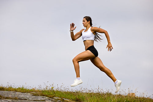 Determined Athlete Running On Mountain Against Sky