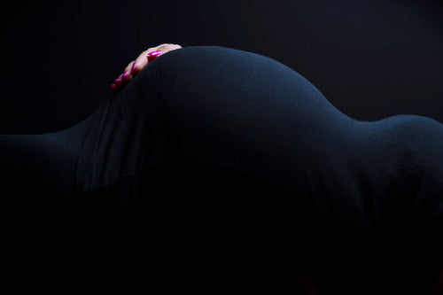 Pregnant woman's body shape with hand at belly