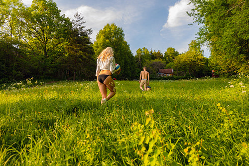 Young Couple Walking On Grass In Idyllic Forest