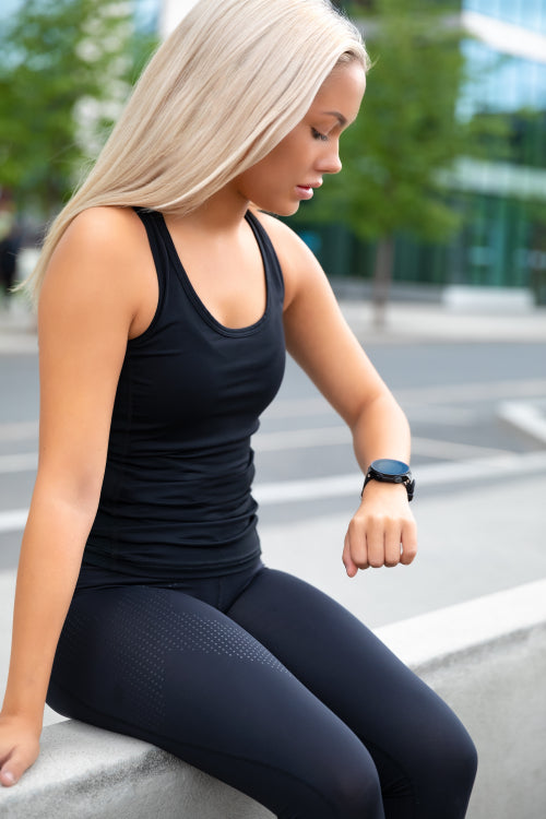 Resting Woman Checking Performance and Tracking On Smartwatch After Exercise