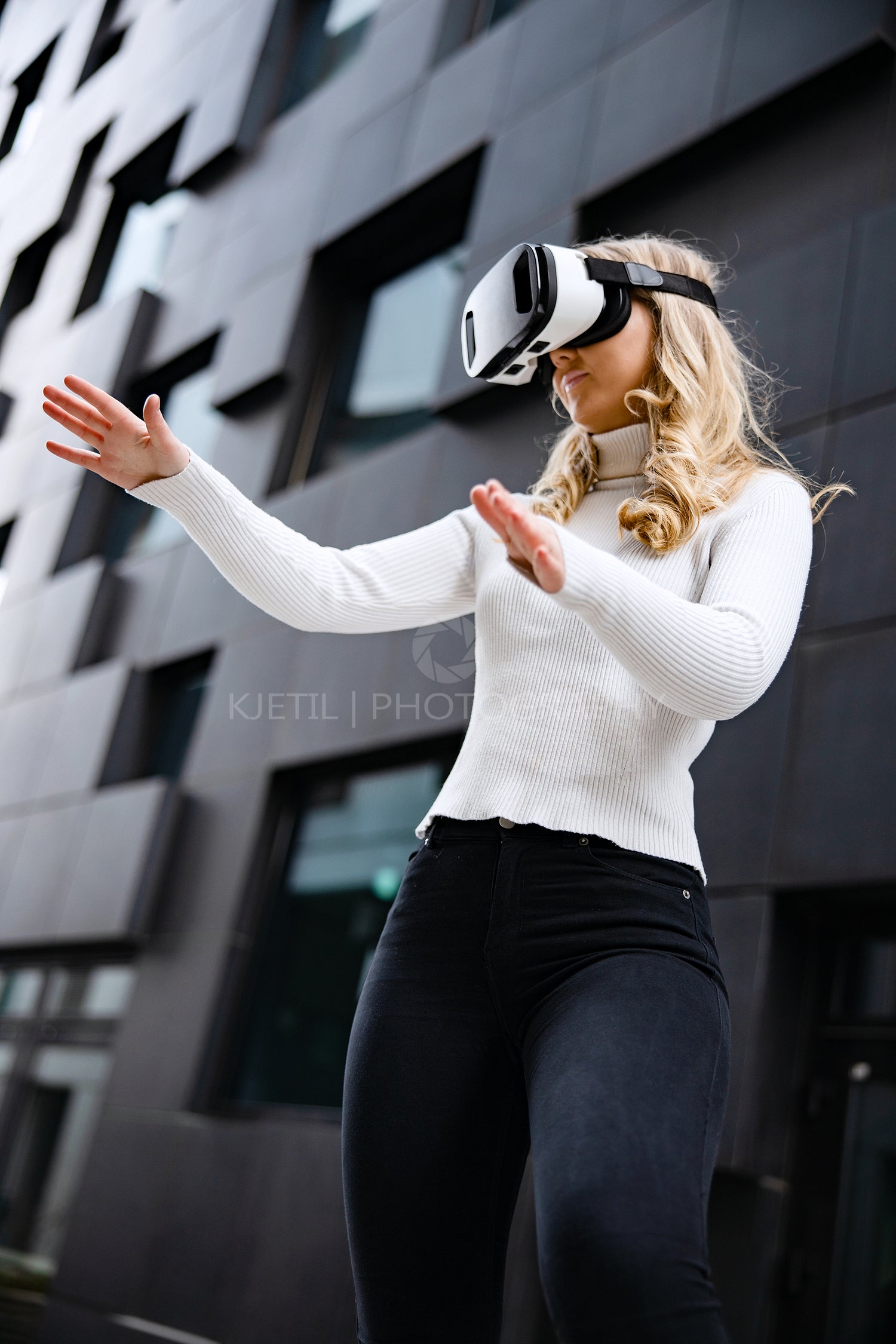 Woman Wearing Virtual Reality Glasses Against Contemporary City Building