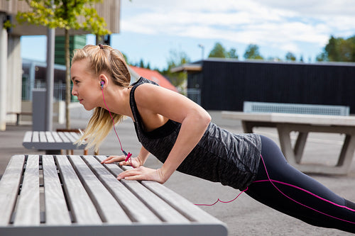 Sporty Young Woman Doing Pushups On Bench In Park