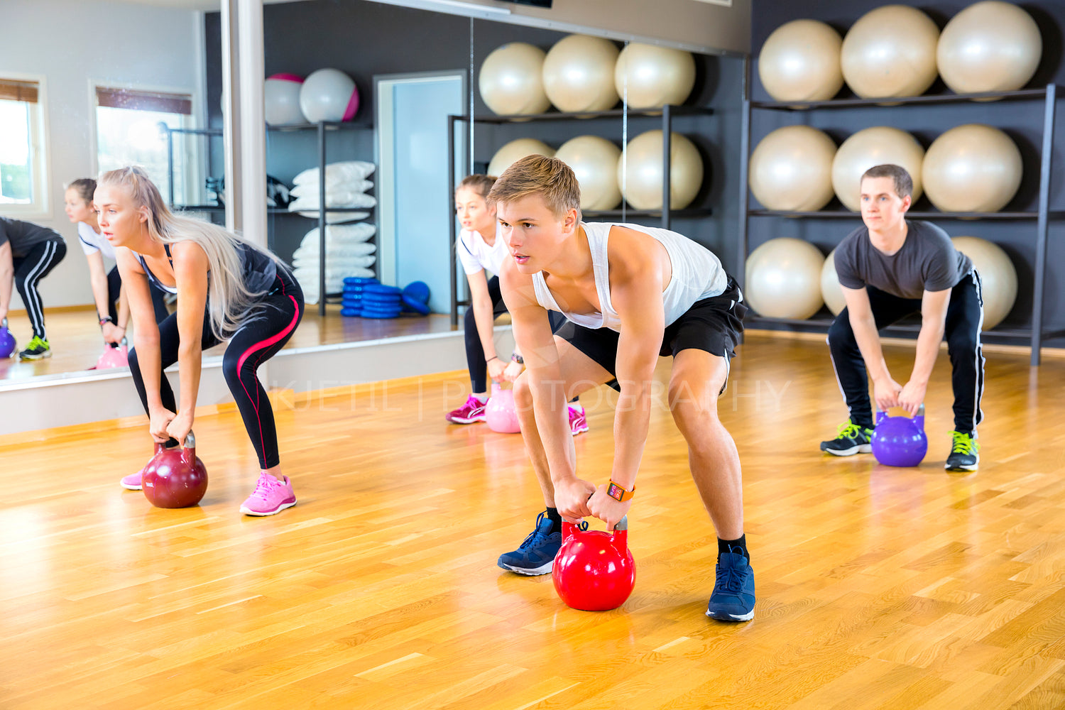 Focused group trains with kettlebells at fitness gym