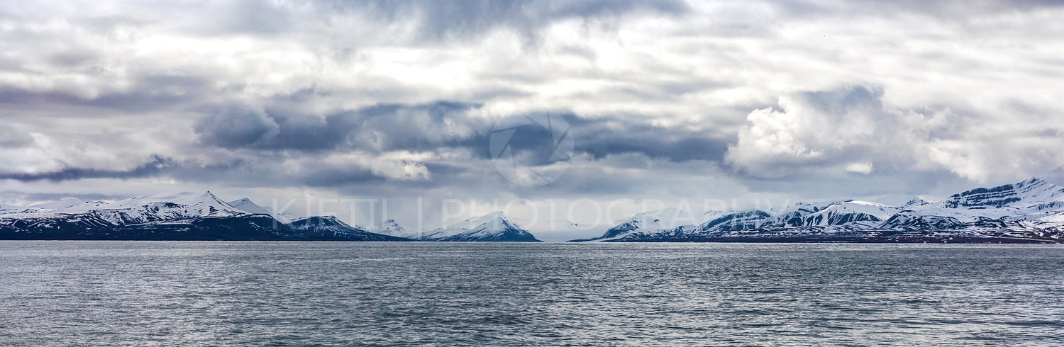 Panorama of clouds over snowy mountains in the arctic