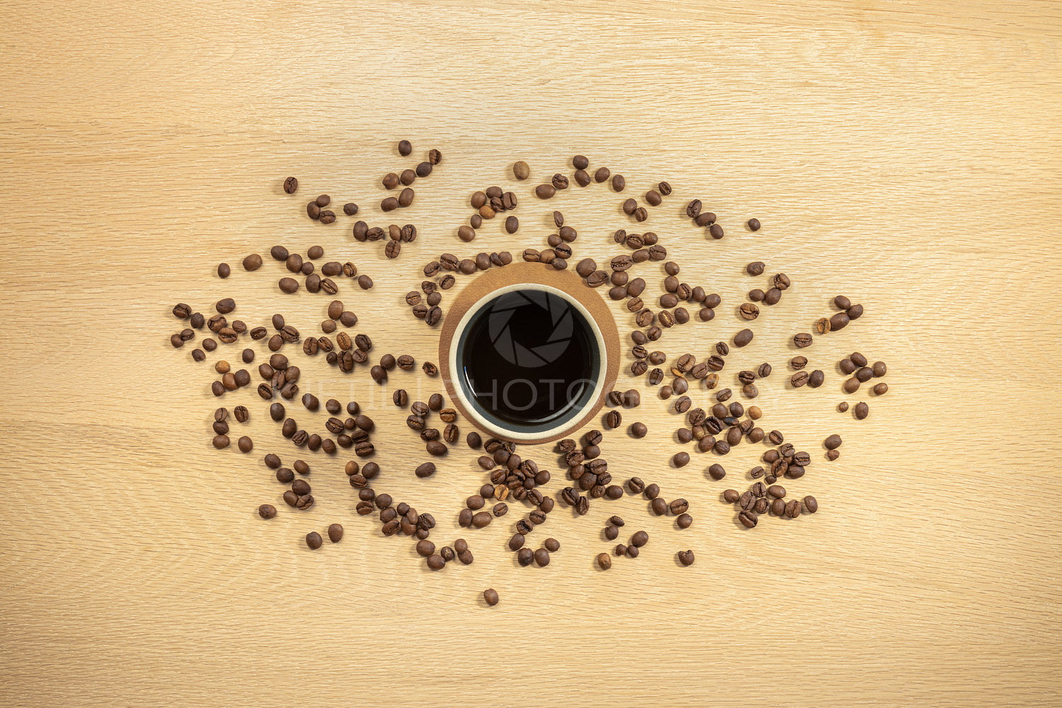 Overhead view of roasted beans and coffee in cup on table