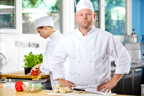 Portrait of confident chef making food in large kitchen