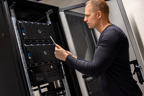 IT Support Holding Digital Tablet Analyzing Servers And Network In Datacenter