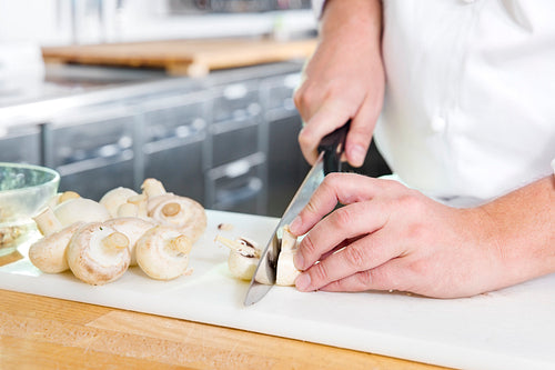 Professional chef cutting mushrooms in the kithcen