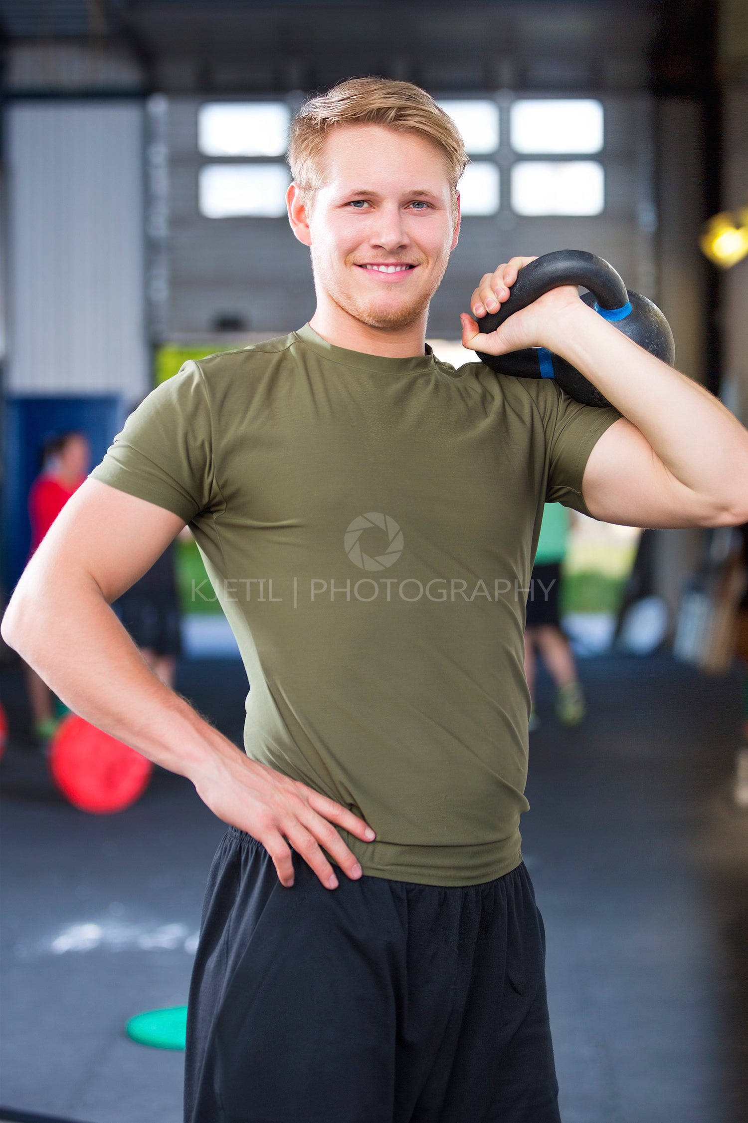 Confident Fit Male Athlete Holding Kettlebell In Health Club