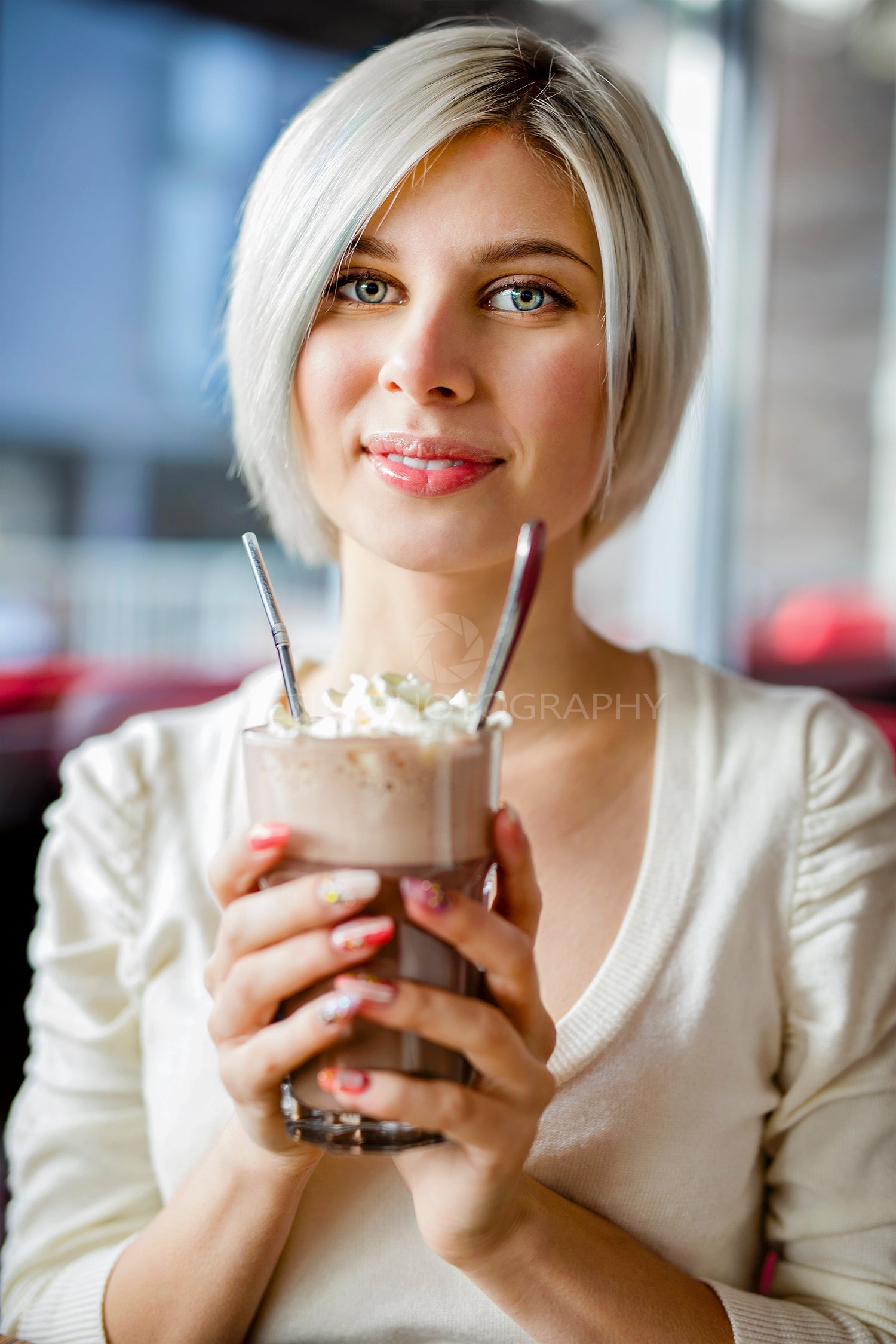 Woman Holding Glass Of Hot Chocolate With Cream In Cafe