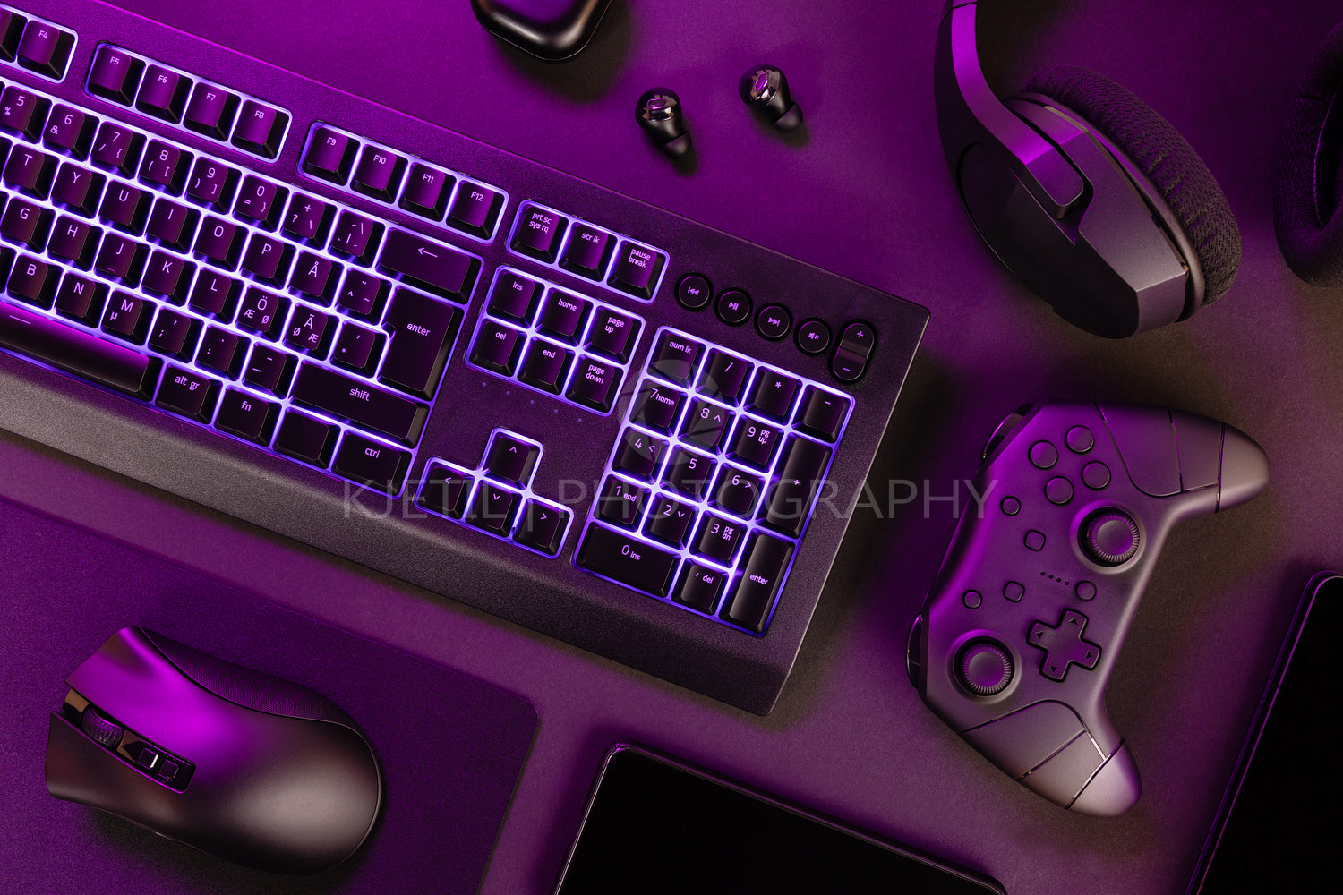 Purple lit keyboard amidst wireless devices