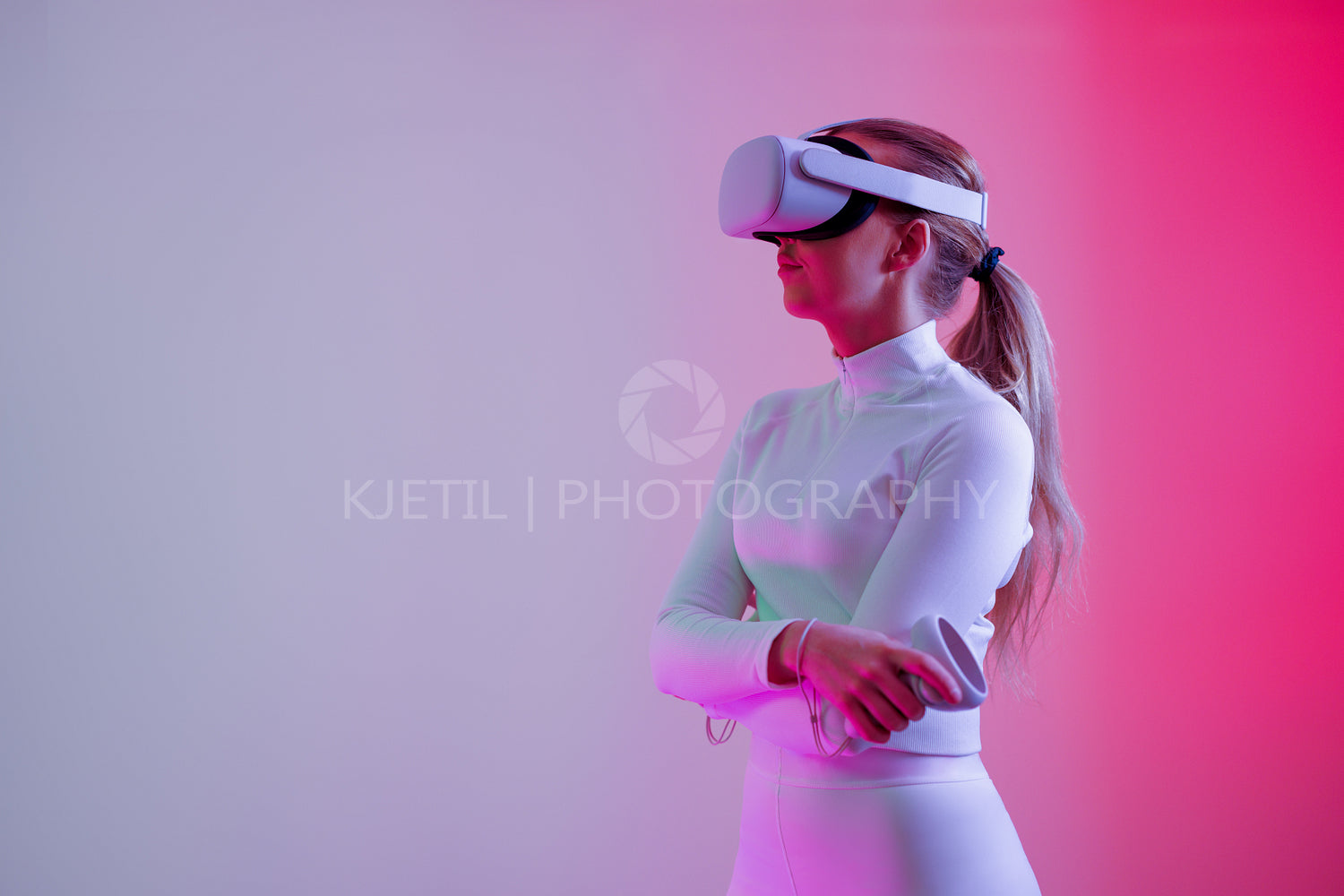 Woman in VR glasses standing with arms crossed in colored room