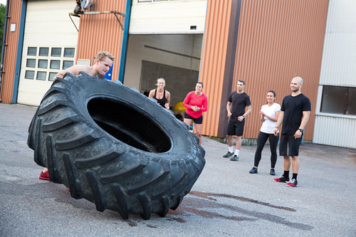 Man flipping heavy tires outdoor as workout