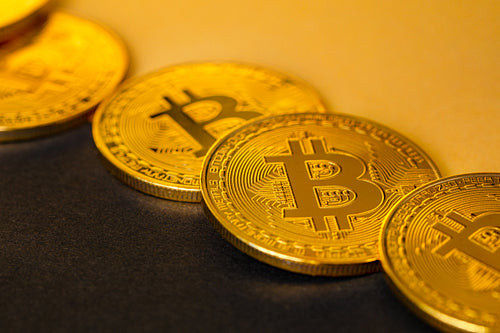 Closeup Of Shiny Bitcoin Crypto Currency Coins on Black and Yellow
