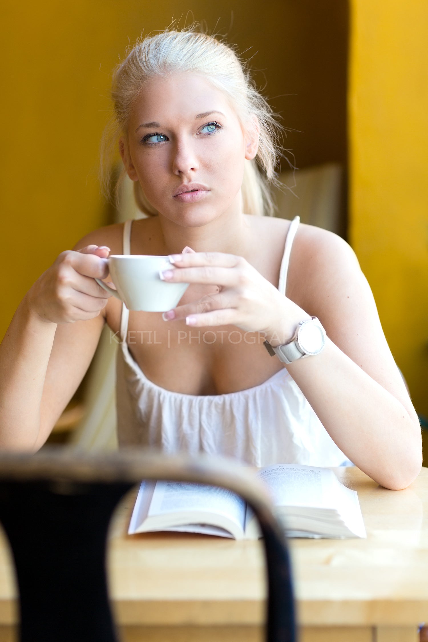 Young blonde woman drinking coffee at cafe