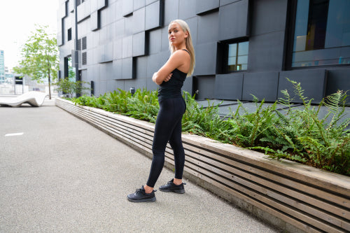 Confident Female Urban Runner Standing With Her Arms Crossed