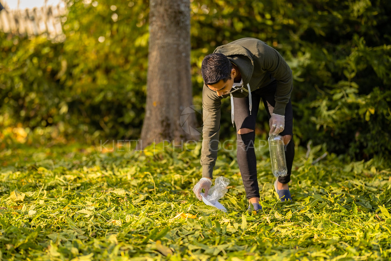 Committed volunteer cleaning garbage on grass in nature
