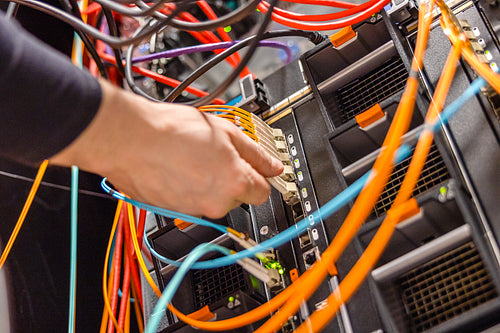 Male Technician Plugging Fiber Channel Network Cable In Blade Server Switch