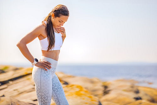 Confident Slim Fitness Woman Standing With Hand On Hip by the Sea