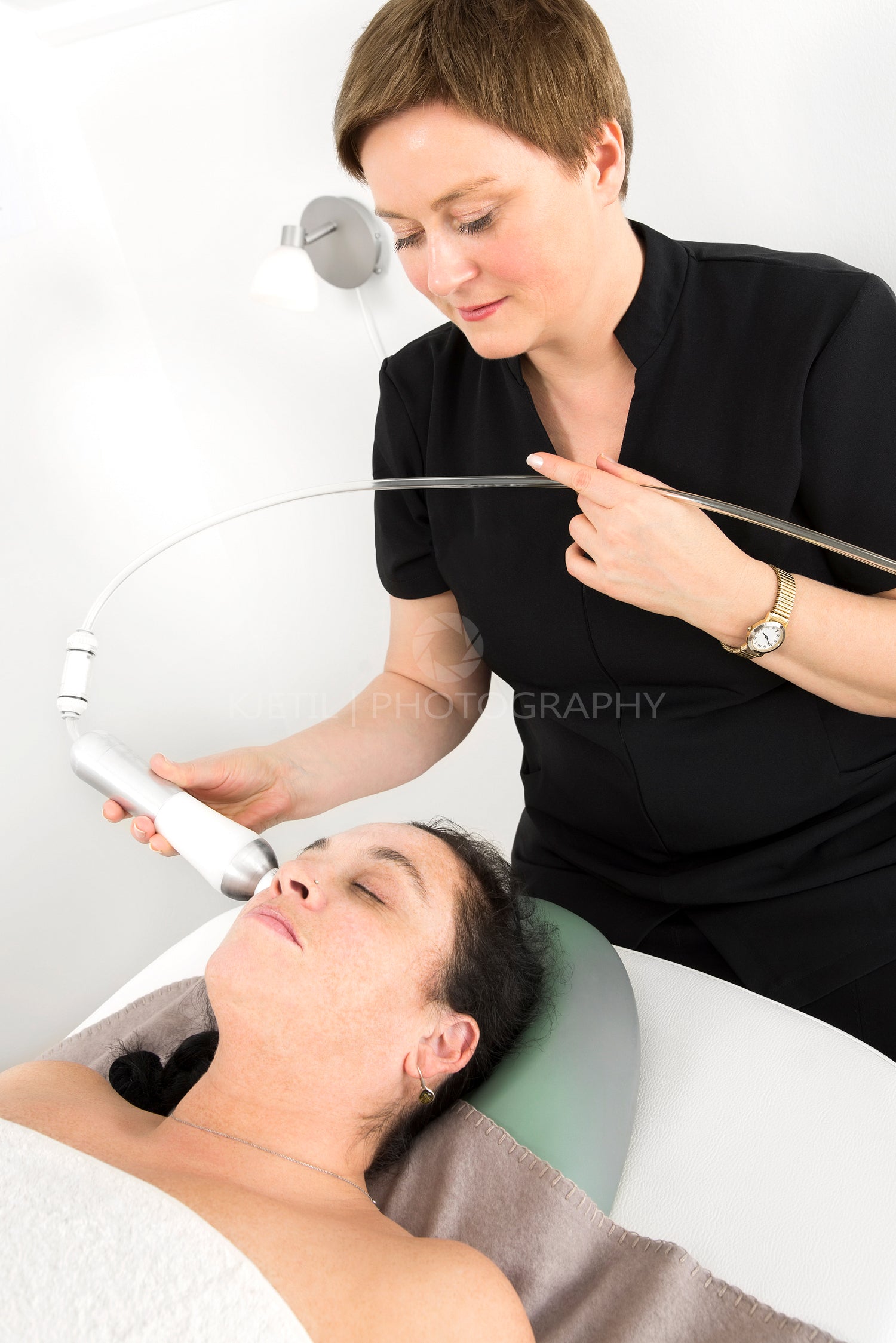 Woman client gets face slimming treatment at beauty clinic