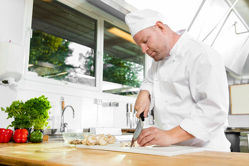 Professional chef preparing vegetables in large kitchen