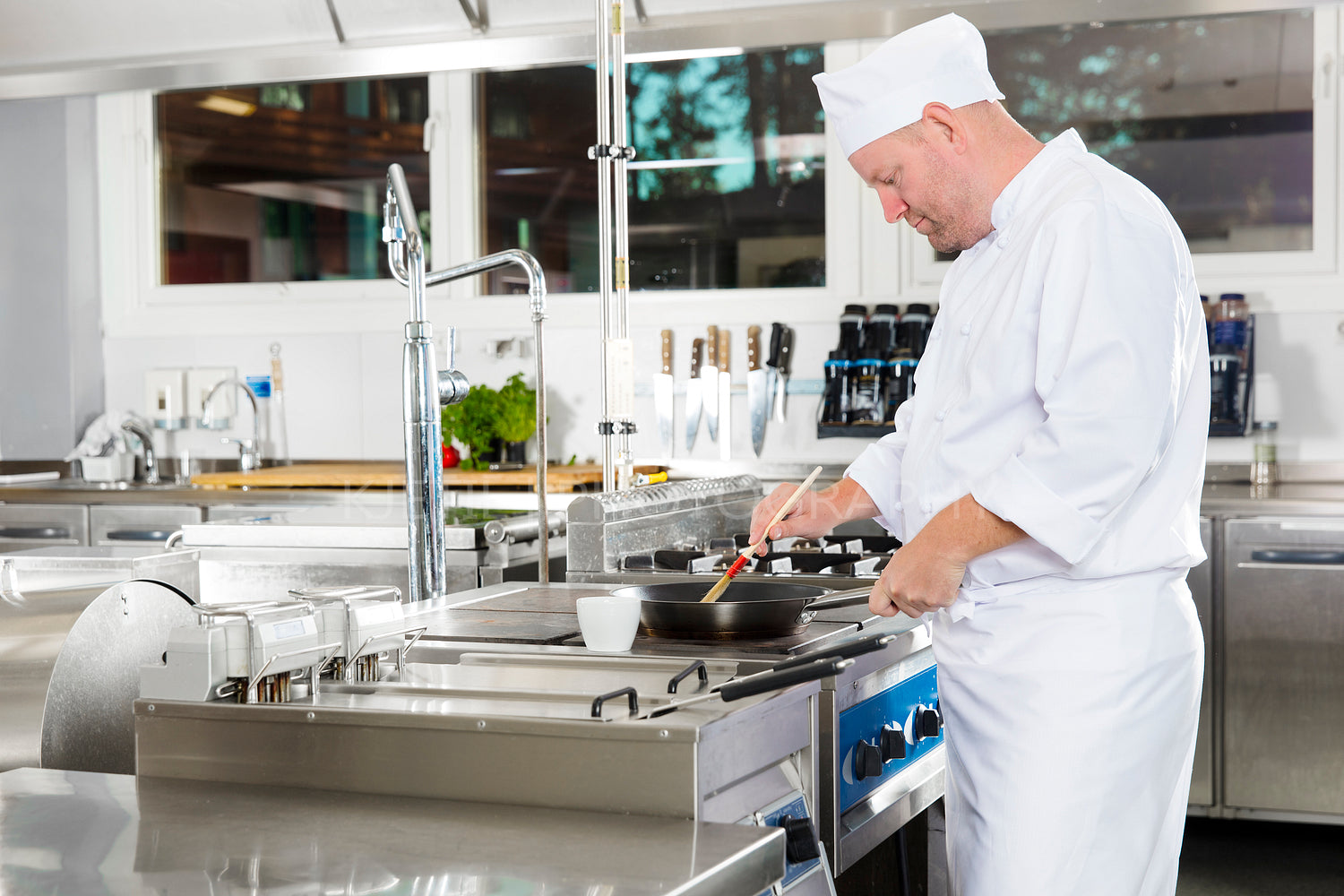 Chef using brush to prepare a dish in the kitchen