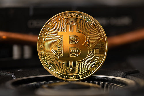 Gold bitcoin standing on crypto mining GPU computer hardware