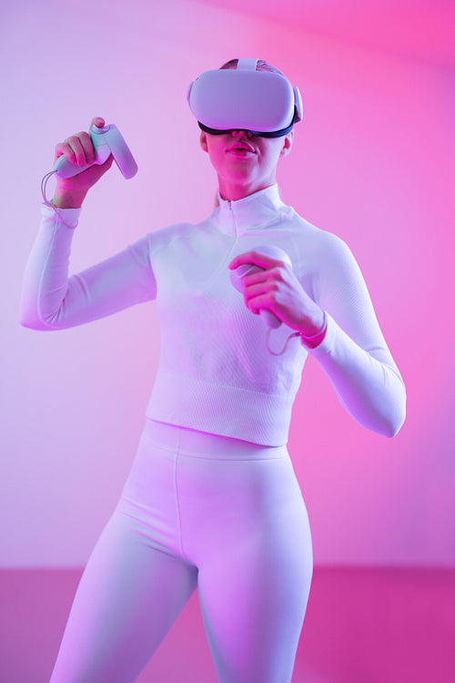 Woman in VR glasses against colored background