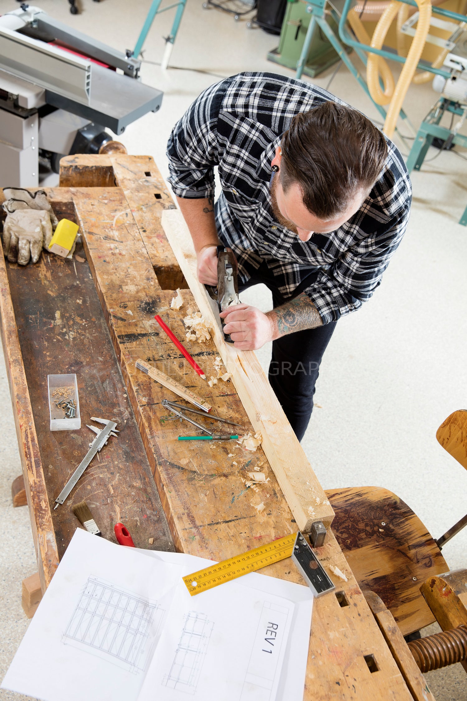 Craftsman work with plane on wood plank in workshop
