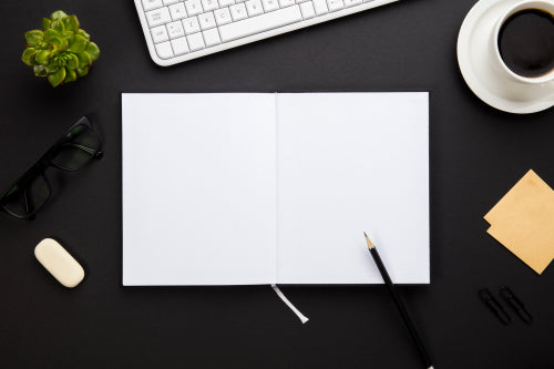 Blank Paper Surrounded By Office Supplies On Gray Desk