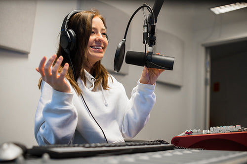 Female Jockey Communicating On Microphone In Radio Studio
