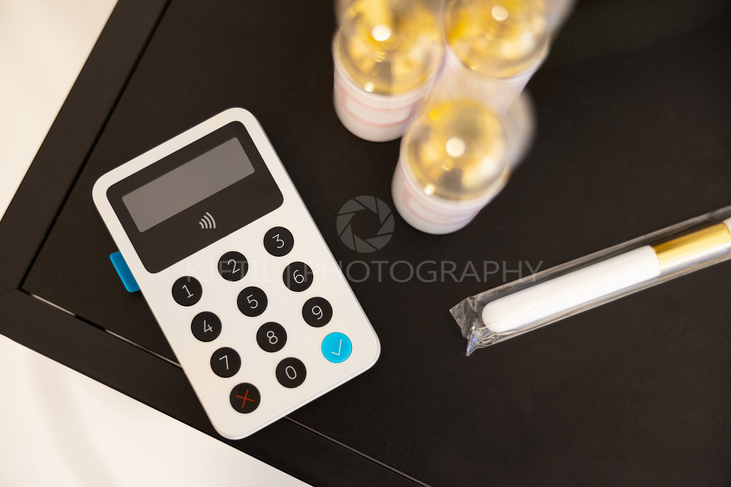 White Card Reader By Beauty Products On Table