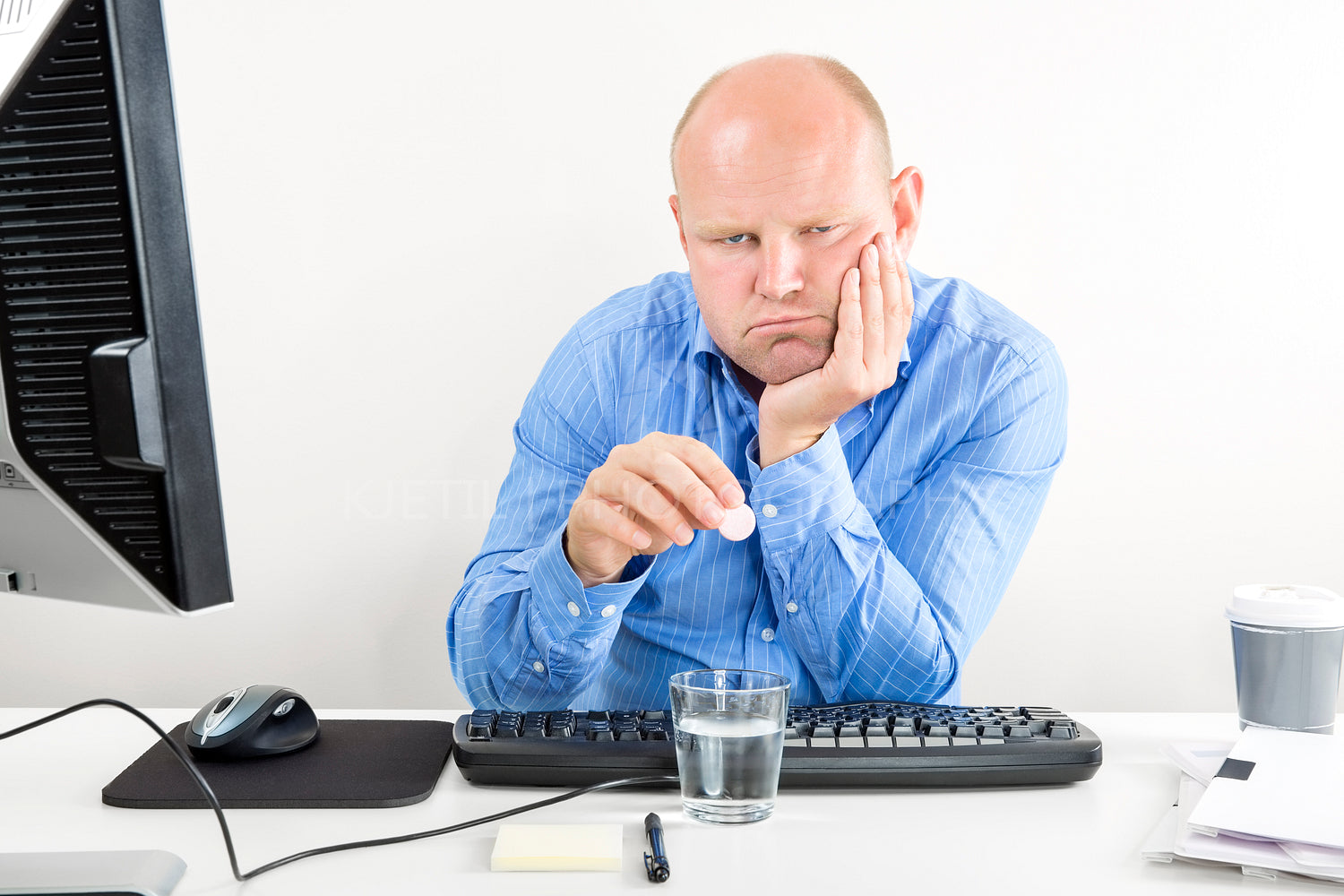 Overworked office worker taking pills for headache