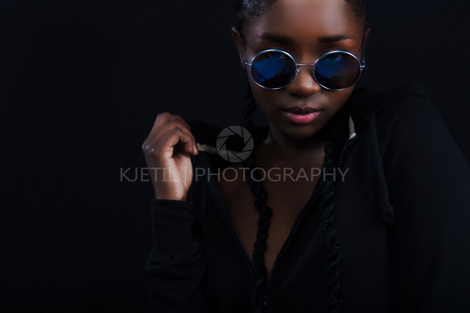 Confident and cool woman with dark skin wearing round sunglasses