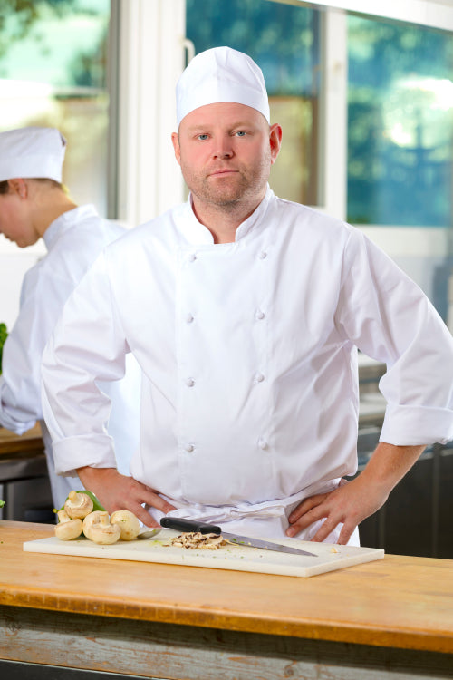 Portrait of confident chef making food in large kitchen