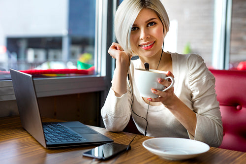 Beautiful Young Woman With Coffee Cup And Laptop In Cafe