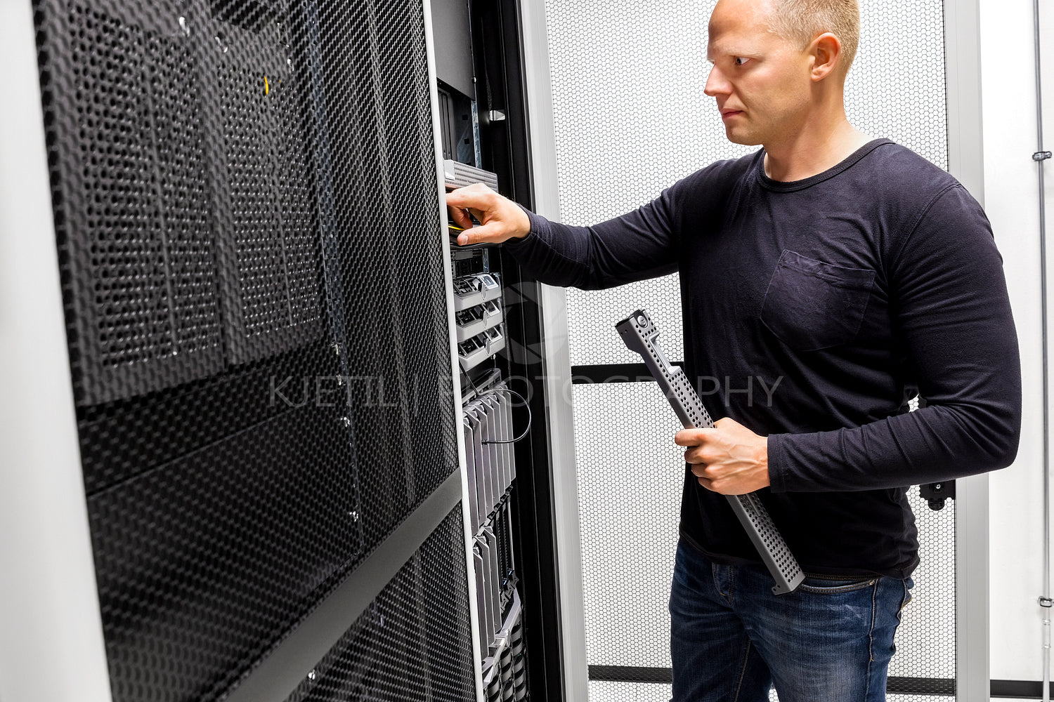 Male Engineer Working On Server At Data Center