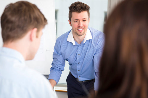 Businessman Smiling While Looking At Colleagues In Office