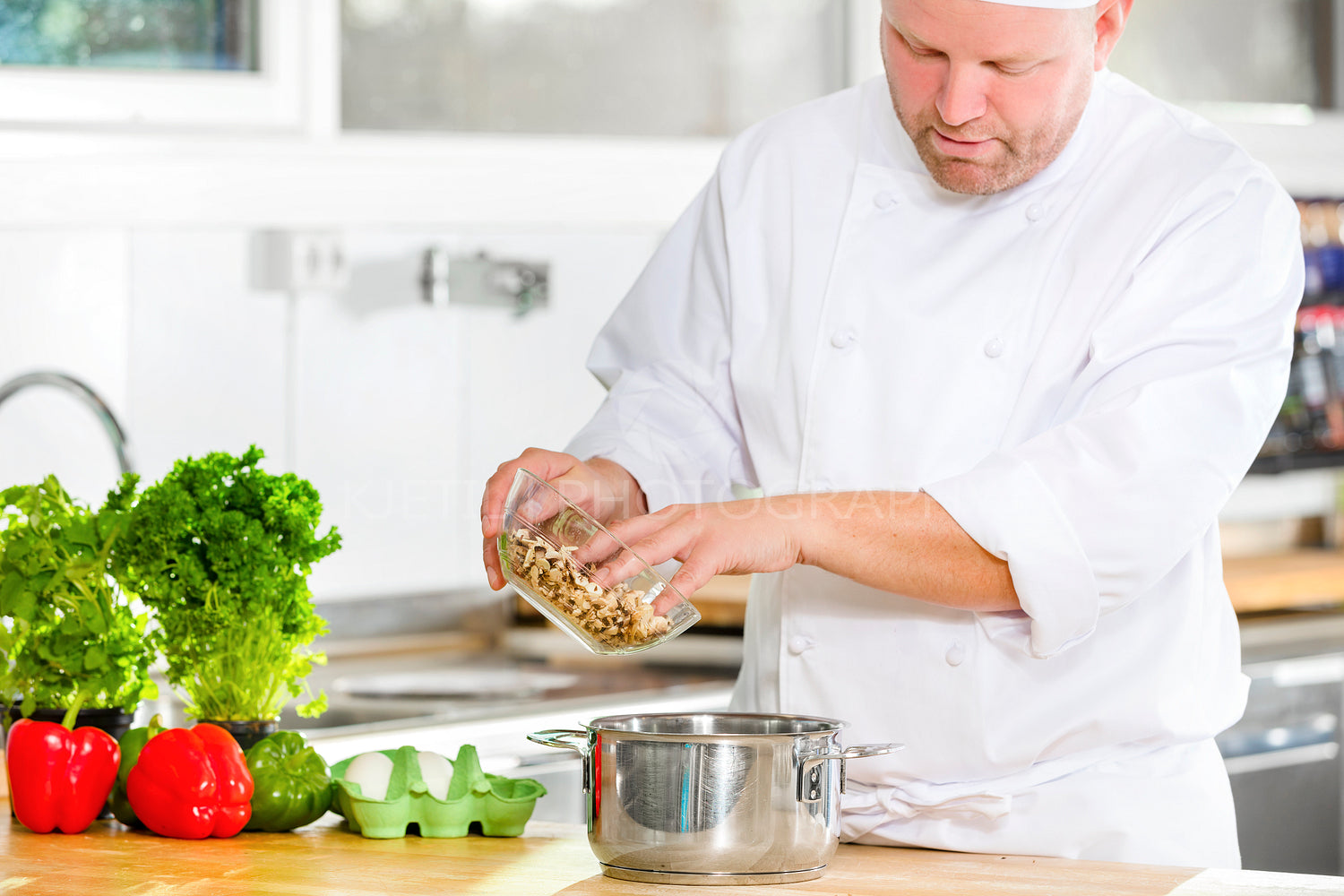 Professional chef preparing food in large kitchen