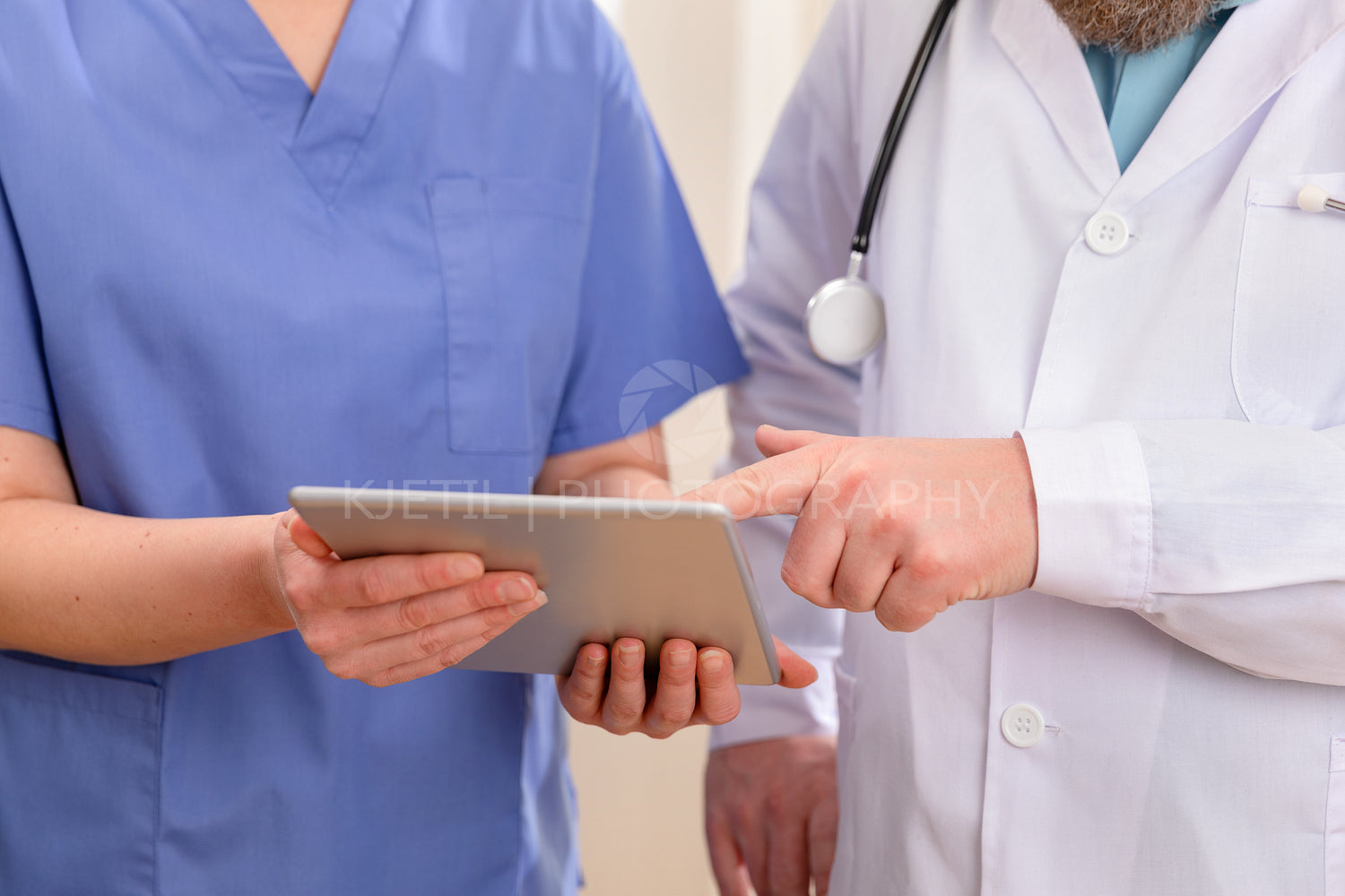 Doctor and nurse discussing patients test results at tablet computer in hospital
