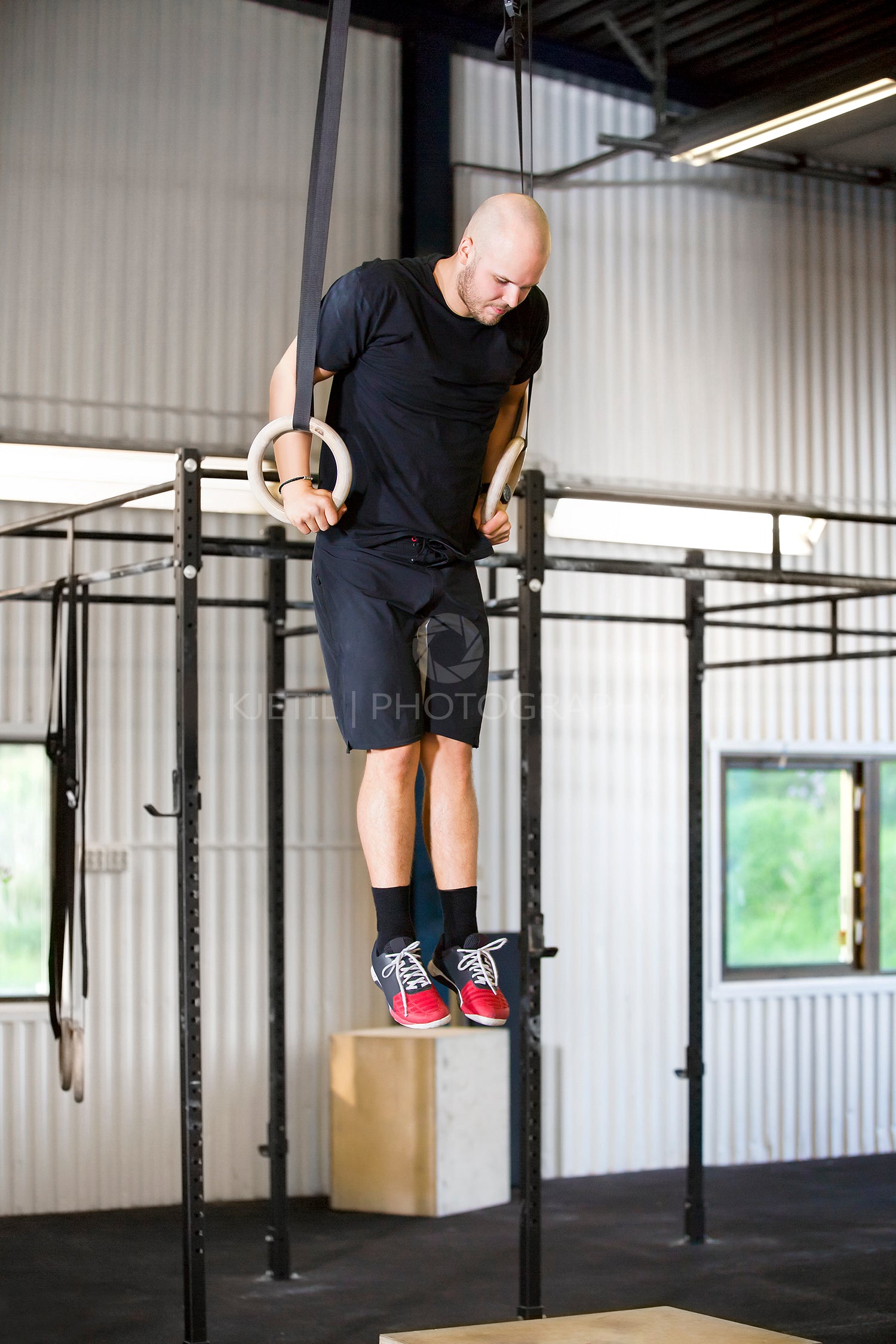 Determined Male Athlete Using Gymnastics Rings In Health Club