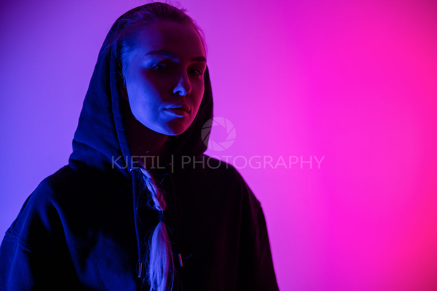 Colorful low-key portrait of a cool and confident blonde woman in hoodie